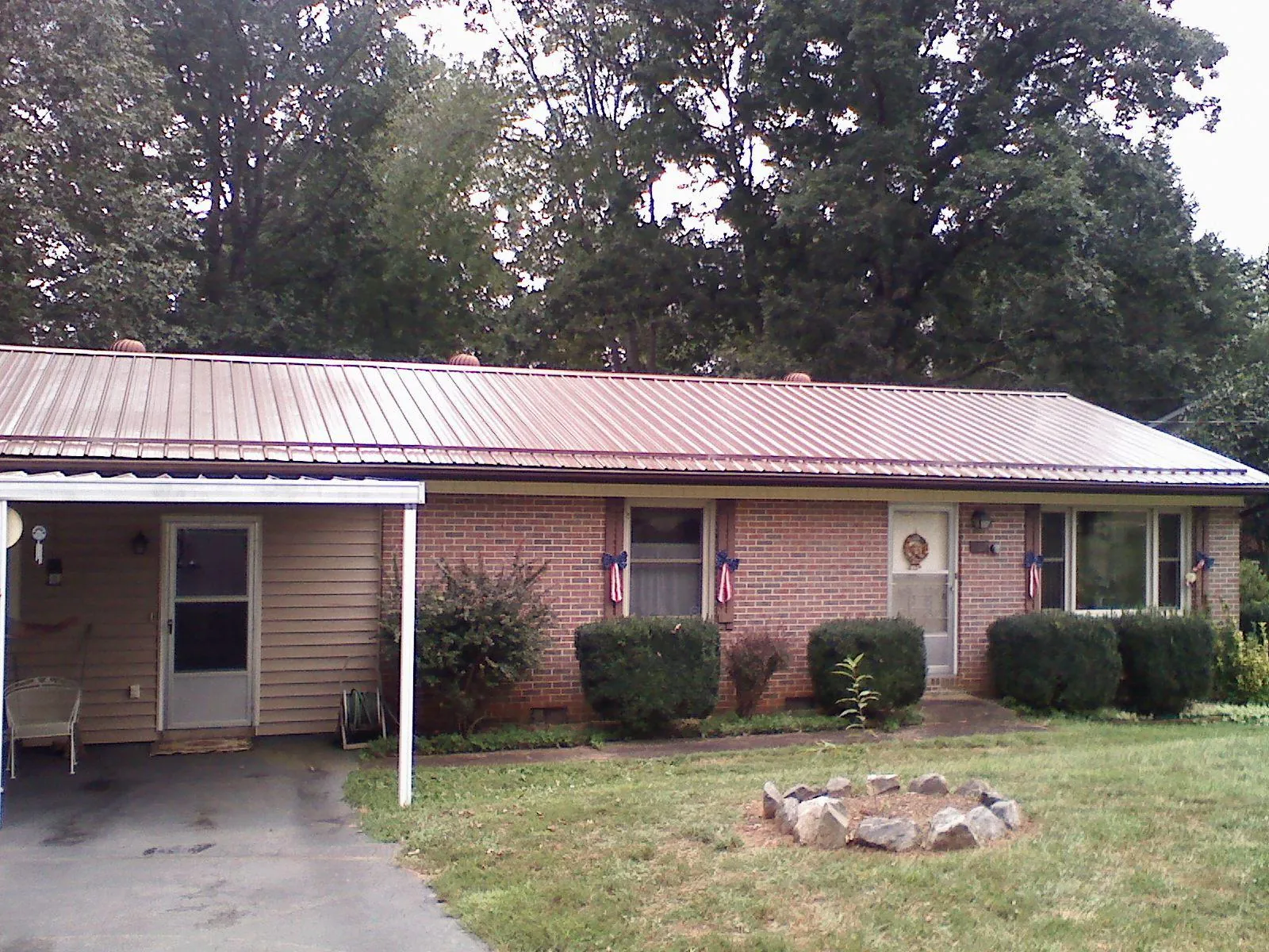 Bronze metal roof and carport on a brick ranch home — Roof Repair work by our crew in Welaka